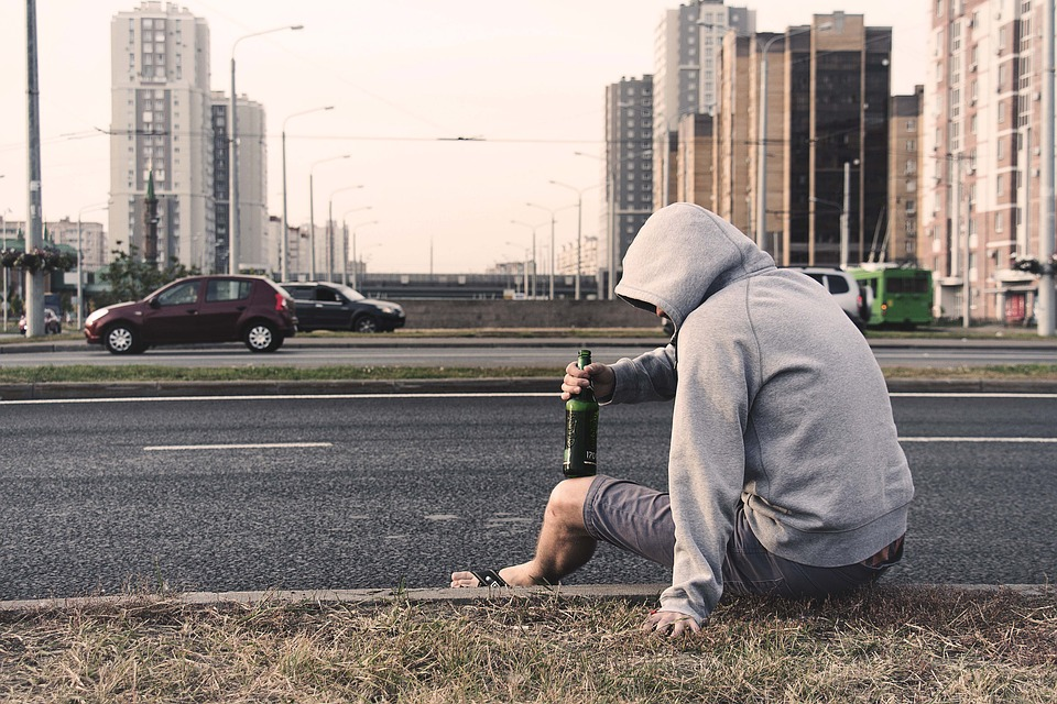 homem alcoólico na beira da estrada.